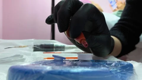 Close up. Master prepares tools for work. Cosmetology procedure. Applying red Video stock 119892159