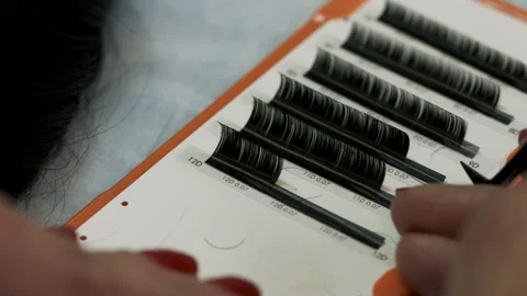 Close-up of master at work with tweezers artificial eyelash extensions material Stock Footage 106957165