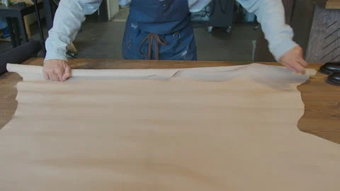 Close-up master's hands rolling out paper in workshop. Shoe manufacturing Stock Footage 137470517