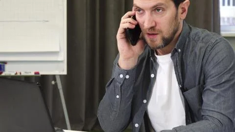 Close up of a mature businessman talking on the phone at the office Stock Photos