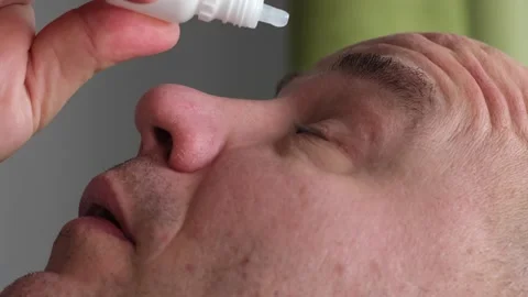 Close up mature man applying eye drops to treat dry eye and irritation at home Video stock 301372335