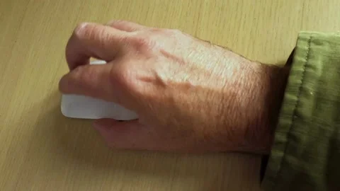 Close up of a mature man using a computer mouse on a light wood laminated Stock Footage 201668427