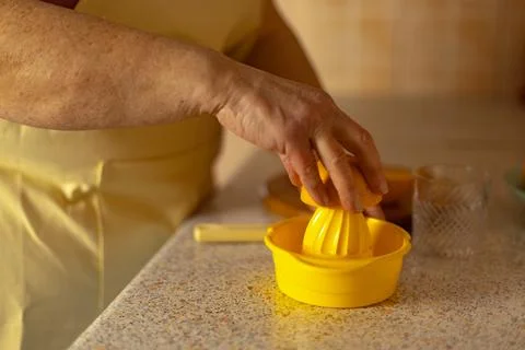 Close-up of a mature woman's hand squeezing juice from an orange Stock Photos