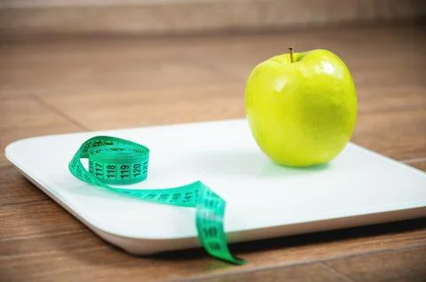 Close up, measuring scale and apple on wooden background. digital scale with Stock Photos