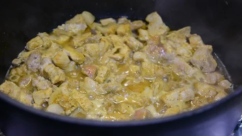 Close up meat and vegetables in cauldron. Pieces of meat and a lot of onions are Stock-Footage 119860438