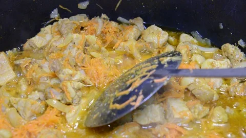 Close up meat and vegetables in cauldron. Pieces of meat and a lot of onions are Vídeo Stock 119860477