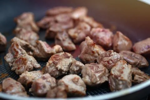 Close up of meat beef cubes chunks in a frying pan Stock Photos