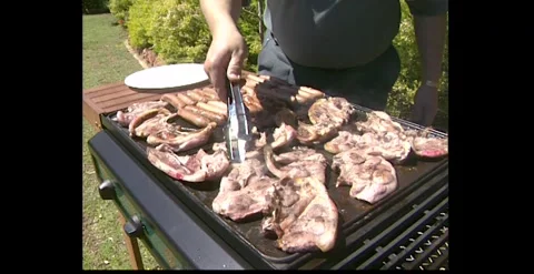 Close Up of Meat Being Cooked on a BBQ Australia 1990s Stock Footage 317804238