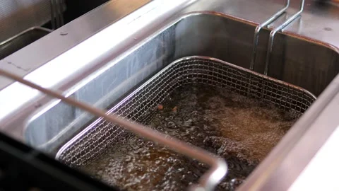 Close-up. The meat dish is placed in a deep fryer. Stock Footage 154741272