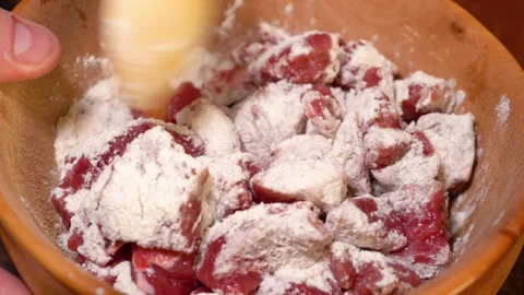 Close up of meat with flour on a plate, mixed with a wooden spatula Stock Footage 248155372
