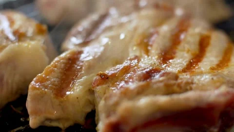 Close up of meat grilling on a hot pan Stock Footage 333836941