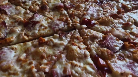 Close-up of a meat pizza with crispy bacon and melted cheese. Video footage of Видео 334492918