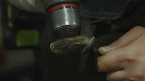 Close-up of mechanic cleaning metal part with rotating wire brush Stock Footage 340273232