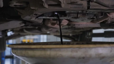 Close-up mechanic drains excess engine oil for the required pressure in the car. Stock Footage 338995770