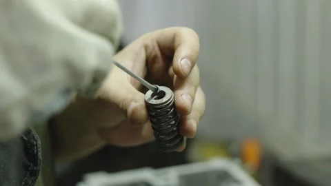 Close-up of mechanic hands installing valve keepers onto engine spring Stock Footage 340273380
