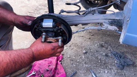 Close-Up of Mechanic Inspecting Rear Wheel Hub Assembly in Workshop Stock Footage 333204031