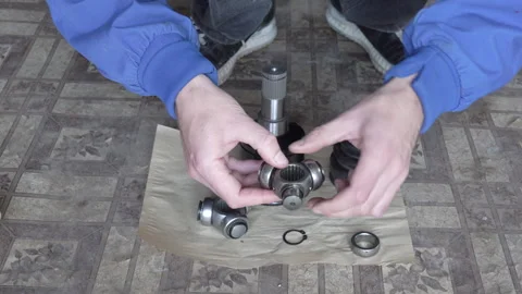 Close-up of a mechanic inspecting a worn tripod CV joint before replacement Stock Footage 327302950