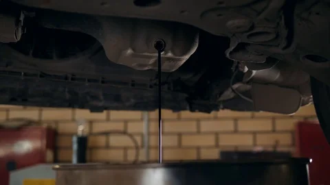 Close up of mechanic man hand at below of a car examining for change engine oil Stock Footage 95261262