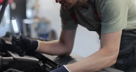 Close up mechanic man with lamp working at workshop. concept car service Stock Footage 341863075