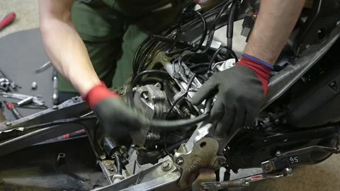 Close-up of a Mechanic Repairing a Motorcycle Engine in a Workshop Video stock 328355035