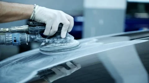 Close-Up of a Mechanic Sanding a Car Panel with a Power Sander Stock Footage 318309712