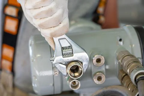 A close-up of a mechanic using an adjustable wrench during equipment maintenance Stock Photos