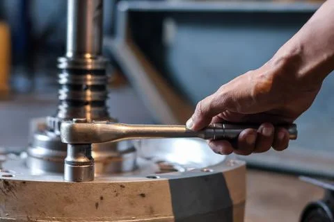 Close Up of Mechanic Using Ratchet Wrench on Transmission Housing Bolt in W.. Stock Photos