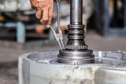 Close Up of Mechanic Using Retaining Ring Pliers on Transmission Shaft in W.. Stock Photos