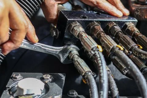 Close Up of Mechanic Using Wrench to Tighten Hydraulic Hose Fittings on Ind.. Stock Photos