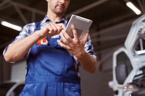 Close up of the mechanic working with the tablet. Stock Photos