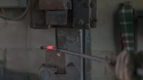 Close up of mechanical blacksmith's hammer working on a steel bar. Stock Footage 249051257