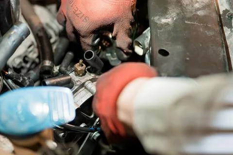 Close-Up of a Mechanic's Hands Working on an Engine Component 스톡 사진