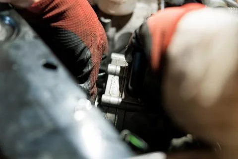 Close-up of a Mechanic's Hands Working on an Engine Component 스톡 사진