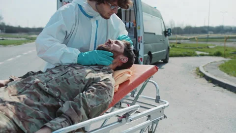 Close up medic provides first aid to wounded soldiers scream in pain in Stock Footage 187704250