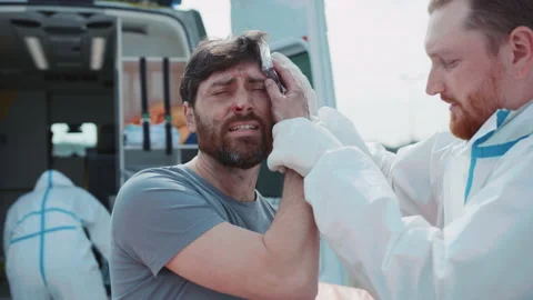 Close up medic provides first aid to wounded soldiers scream in pain near Stock Footage 187713390