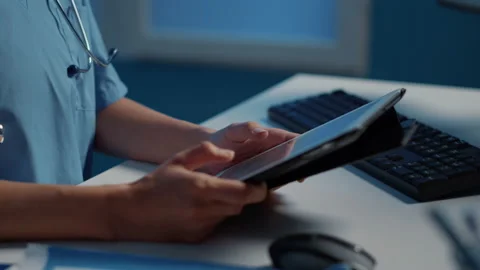 Close up of medical assistant holding tablet computer analyzing patient 動画素材 222736889