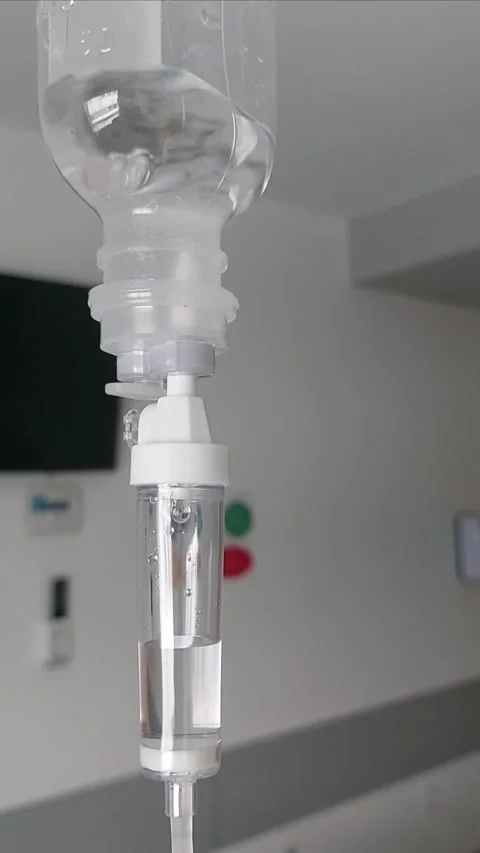 Close up of medical IV drip system with saline solution in hospital Stock Footage 338311076