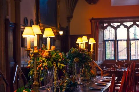 Close up medieval british castle interior dining table with plates, flowers a Stock Photos