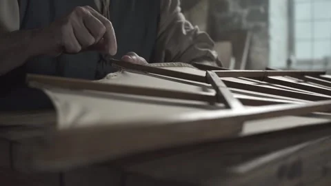 Close up of medieval master hands wrapping thread around ornithopter wing rib Video stock 340080034