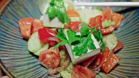 Close up of a Mediterranean style salad featuring fresh cucumber slices, ripe Stock Footage 335524399