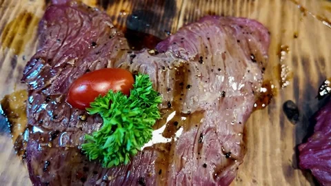 Close Up of Medium Rare Grilled Beef Steak with Parsley and Cherry Tomato Stock Footage 337227305