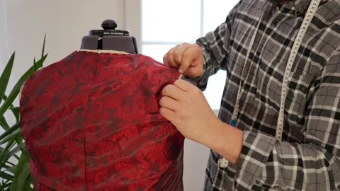 Close up medium shot of Tailor sewing lining inside bespoke hand made vest for Video stock 144613060