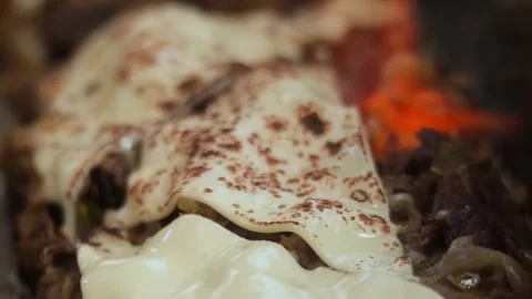 Close-Up of Melted Cheese Over Sizzling Steak and Onions Skillet - Gourmet Comfo Stock Footage 331636598