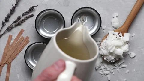 Close up of melted soy wax gets poured into small cans Stock Footage 230111135