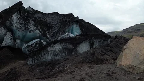 Close-up of melting glacier ice with dark volcanic dust and debris layers Stock-Footage 334736810