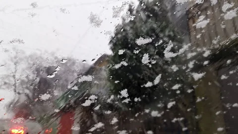 Close-up of melting snowflakes on windshield from inside a car Stock Footage 341023227