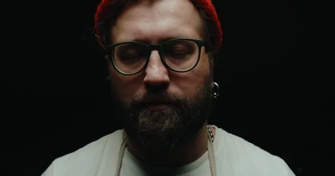 Close-up, men with beards and glasses. Dramatic light, man closes his eyes Stock Footage 219854417