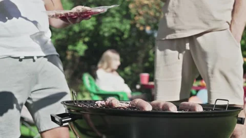 Close up of men grilling bacon on grid. Friends are camping in weekend. Stock Footage 143469833