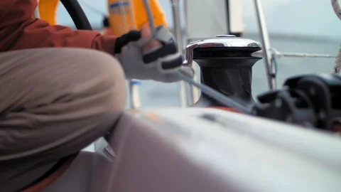 Close up. Men hands in gloves wind the rope on sail winch. Hand of sailor on Stock Footage 88409864