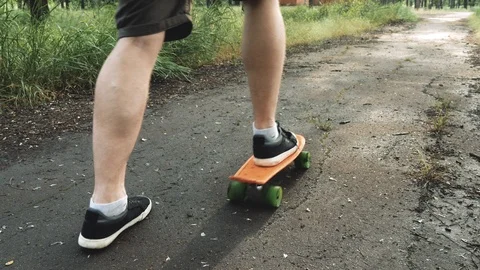 Close up of men legs start ride on board in the summer park. Skater boy ride  Stock Footage 110705363